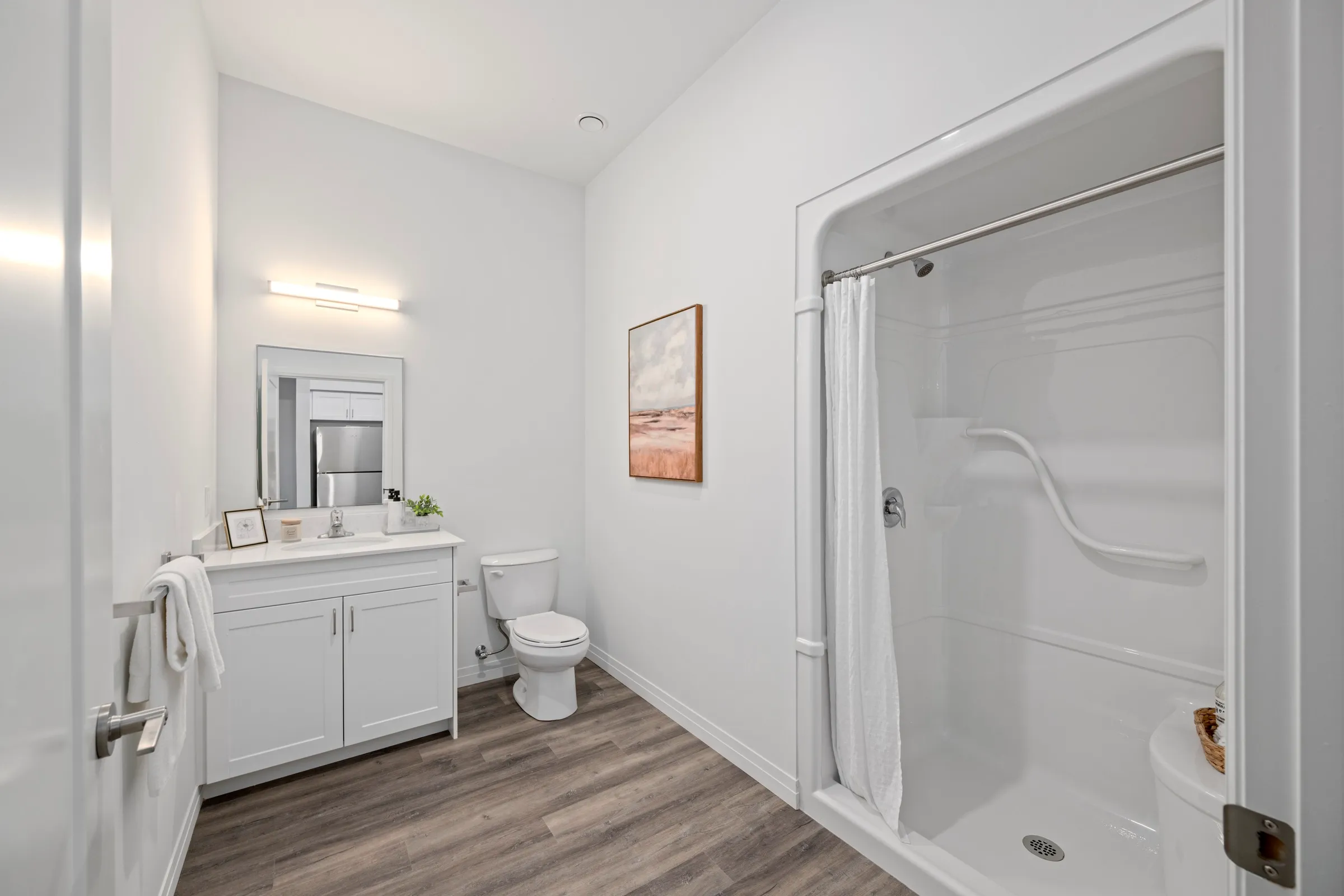Bathroom with a tub and shower, a vanity and large format tile