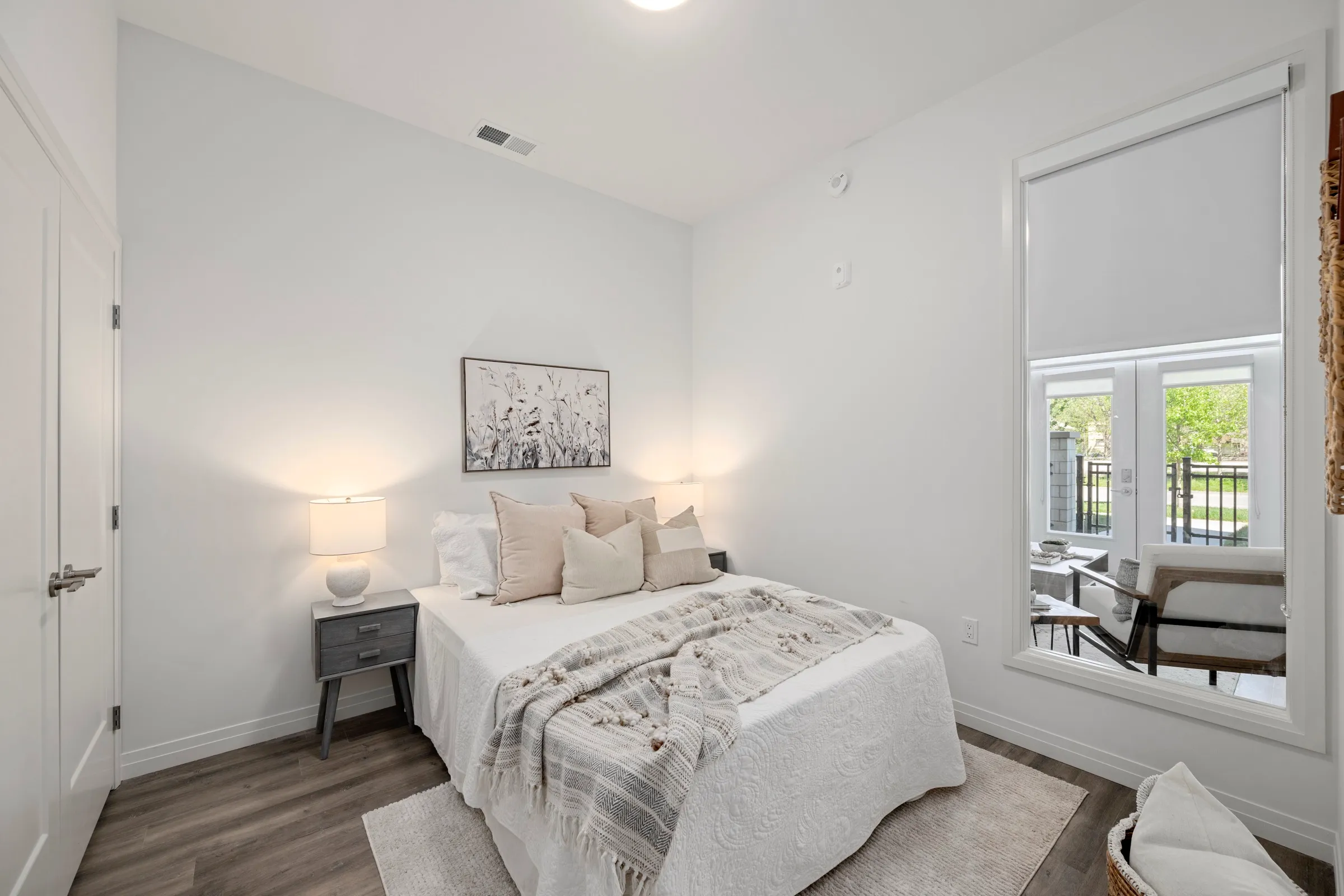 Second bedroom with warm light and plants by the window