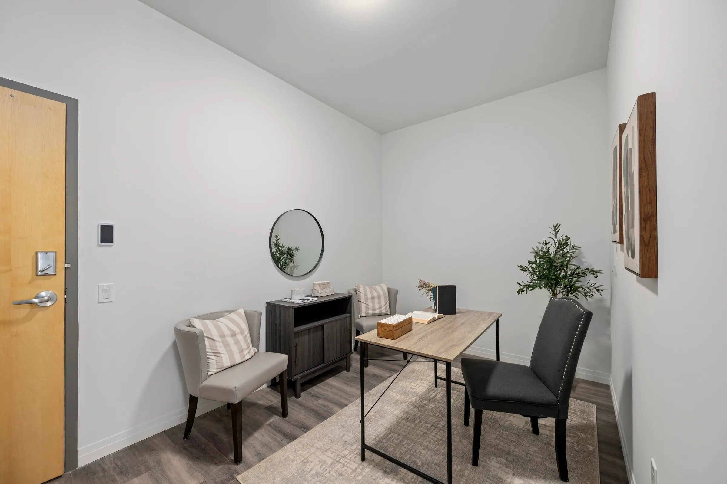 Den set up as a home office, with a desk and a chair beside the window